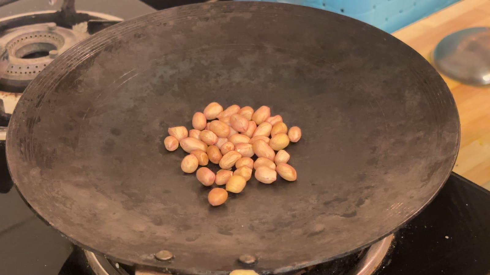 तव्यावर भाजण्यासाठी ठेवलेले शेंगदाणे